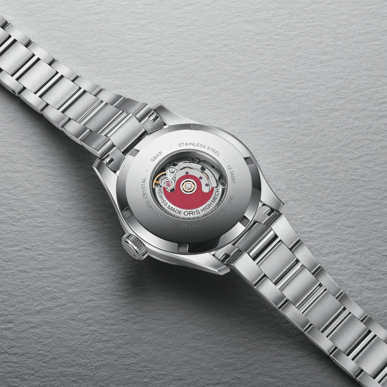 The Oris Big Crown Pointer Date is shown face down, revealing its transparent case back and visible Swiss Made automatic mechanical movement with Oris branding.