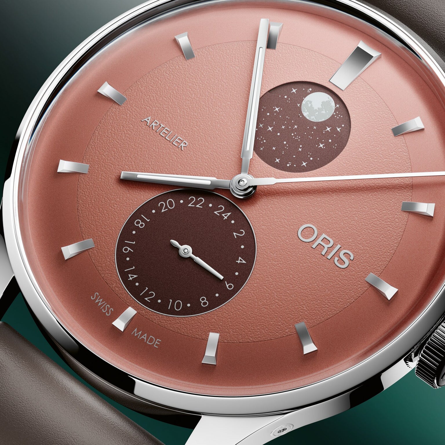 Oris watch with coral dial, silver baton markers, moonphase complication at 3 o'clock, and date window at 6 o'clock.