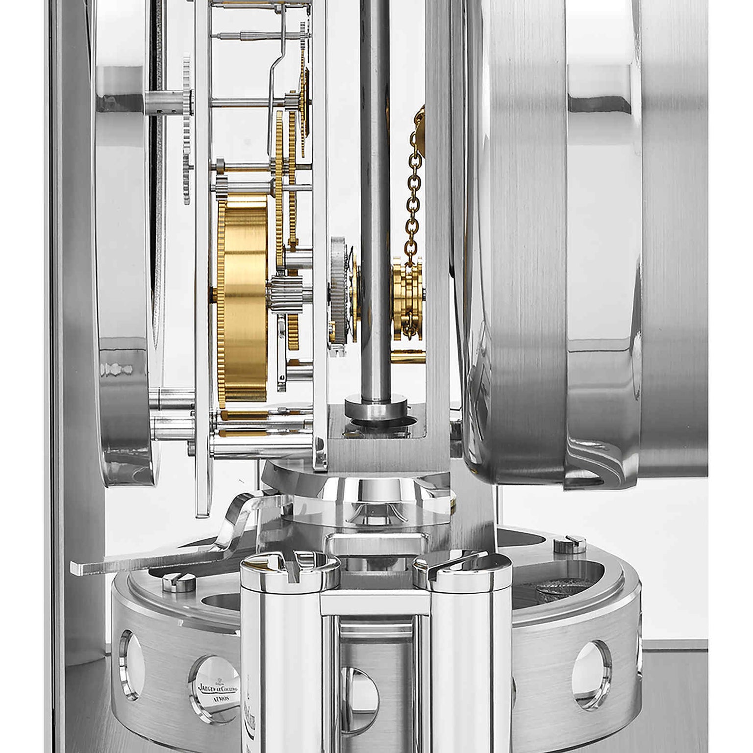 Close-up view of the Jaeger-LeCoultre Atmos Classique, featuring intricate golden gears, silver components, and polished cylinders that highlight its precise engineering and unique perpetual movement.