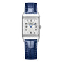 The Jaeger-LeCoultre Reverso Classic Small is a rectangular silver wristwatch with a blue leather strap, silver dial, black Arabic numerals, blue hands, art deco-style case lines, and a right-side crown.