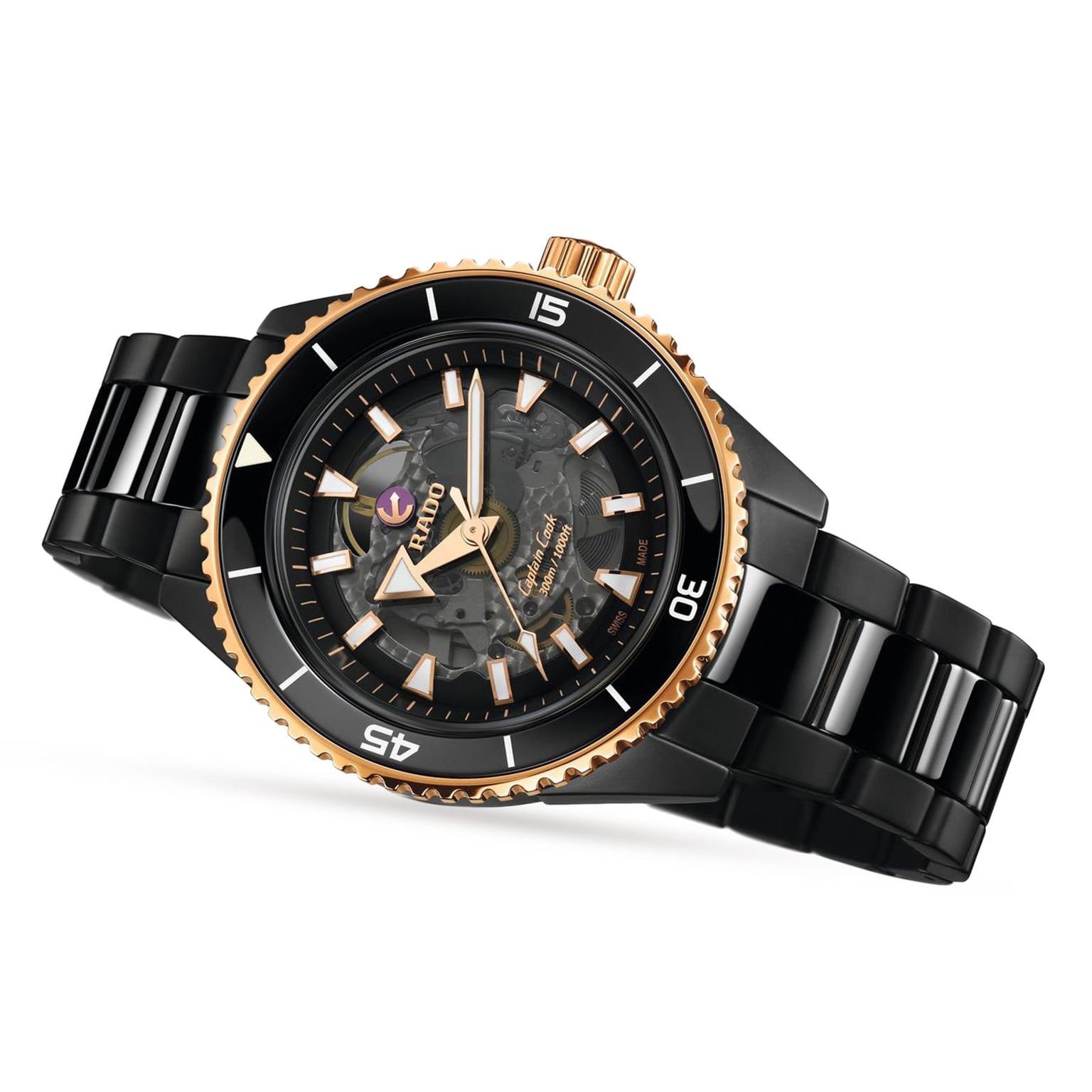 The Rado Captain Cook High-Tech Ceramic wristwatch features a black ceramic band, gold bezel, black dial with luminous markers, and high-tech ceramic elements, showcased at an angle on a white background.