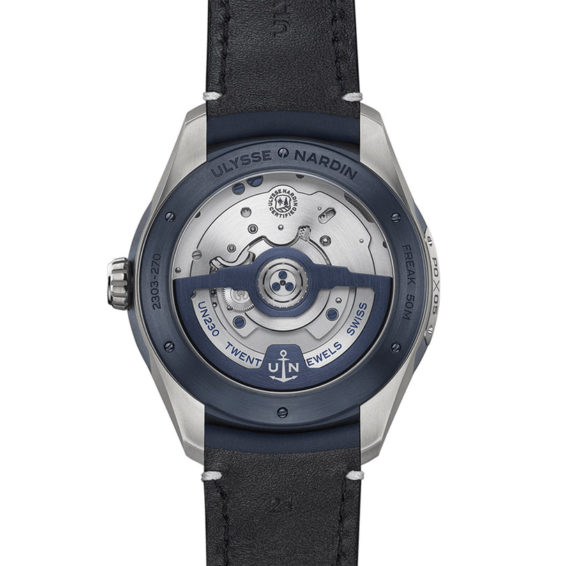 Close-up of the back of the Ulysse Nardin Freak X Ti Blue, highlighting its automatic movement, rotor, and engraved details on the metal case and rim.