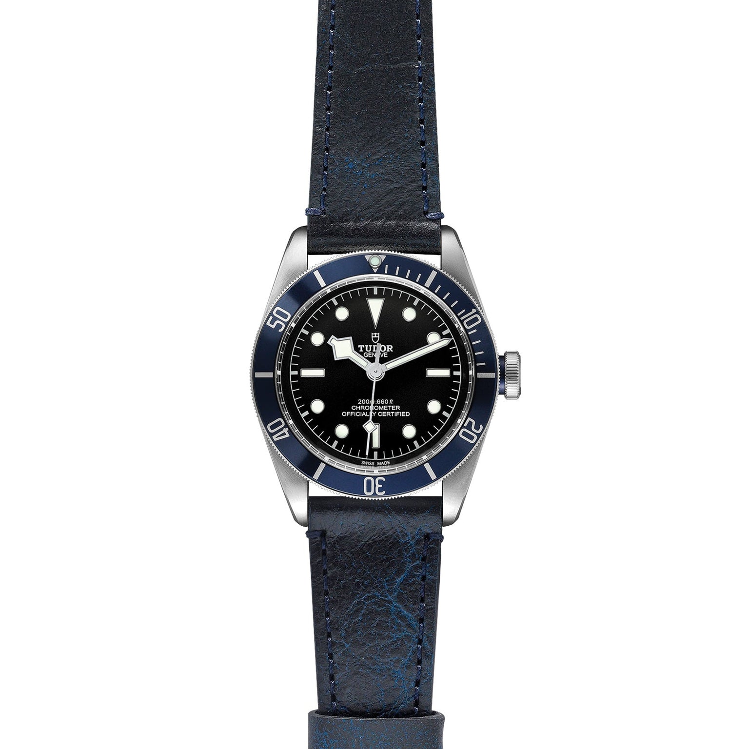 A TUDOR Black Bay wristwatch, with a black dial, white hour markers, blue bezel, and blue leather strap, is displayed on a white background—a striking modern diver’s watch.