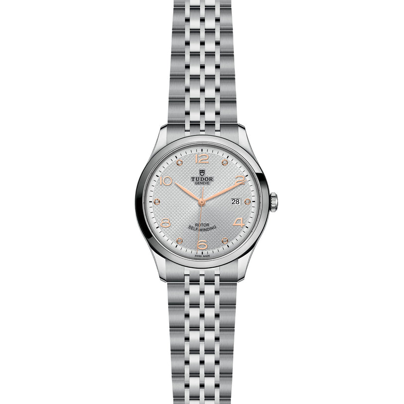 A TUDOR 1926 wristwatch in silver features a metal link bracelet, white textured dial, gold-tone numerals and hands, date window at 3 oclock, and self-winding mechanical movement.