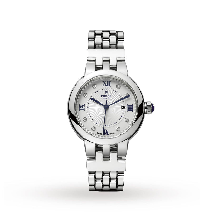 The TUDOR Clair de Rose is a silver wristwatch featuring a round face with Roman numerals, diamond hour markers, and a metal link bracelet.
