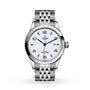 The TUDOR 1926 wristwatch features a silver case, white textured dial with blue markers, a date window at 3 o’clock, and is displayed on a metal link bracelet against a white background—an elegant classic from TUDOR.