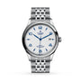 The TUDOR 1926 is a stainless steel wristwatch with a white textured dial, blue Arabic numerals and hands, a date display at 3 o’clock, and a polished silver bracelet that showcases TUDOR’s mechanical watch expertise.