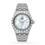The TUDOR Royal is a silver automatic wristwatch with a metal bracelet, fluted bezel, mother-of-pearl dial, diamond hour markers, Roman numerals, and a date window at 3 o’clock—timeless sport-chic style.