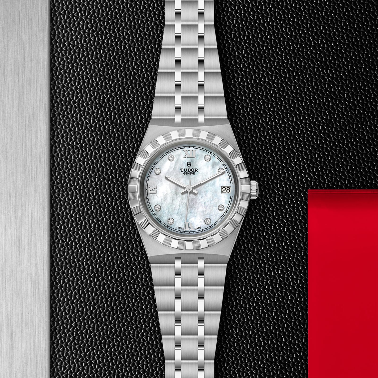 The TUDOR Royal, a stainless steel wristwatch with a mother-of-pearl dial, diamond hour markers, and date window—an automatic sport-chic timepiece—stands out on a textured black background with red and metallic highlights.