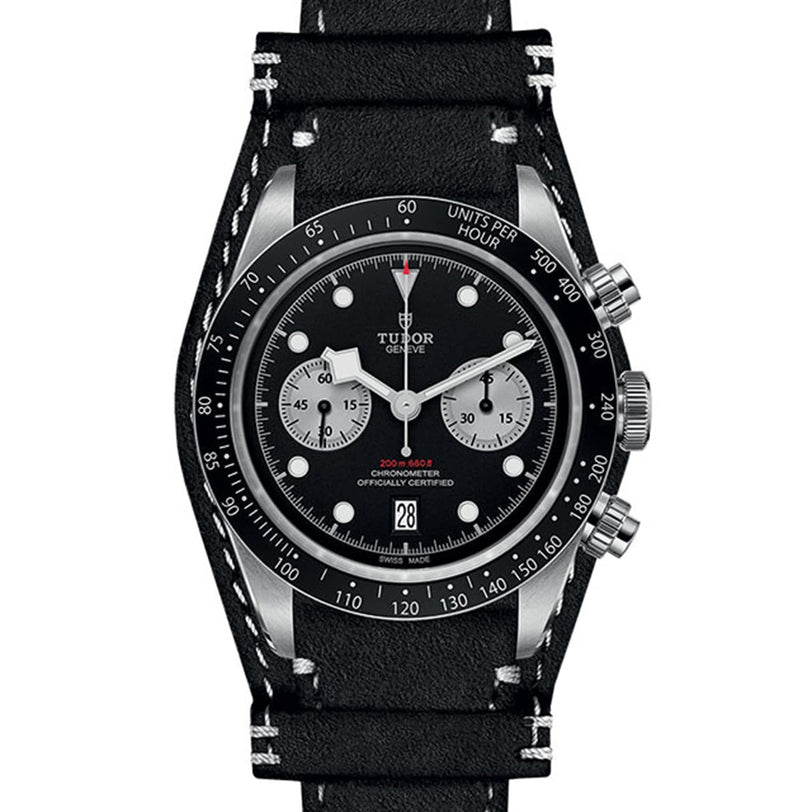 The TUDOR Black Bay Chrono features a black dial, two silver subdials, black bezel, date at 6 oclock, and a black leather strap with white stitching—combining classic chronograph heritage with modern elegance.