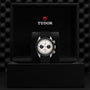 A TUDOR Black Bay Chrono with a black strap and white dial stands upright in an open black TUDOR box, highlighting its signature chronograph style and tachymetric scale.