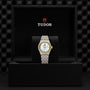 A TUDOR Royal wristwatch with a gold and silver band displayed in a black TUDOR box.