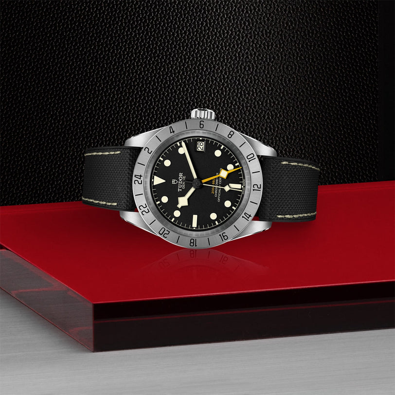 A TUDOR Black Bay Pro rests elegantly on a red box, embodying the neo-vintage charm inspired by classic TUDOR divers’ watches.