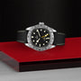 A TUDOR Black Bay Pro rests elegantly on a red box, embodying the neo-vintage charm inspired by classic TUDOR divers’ watches.