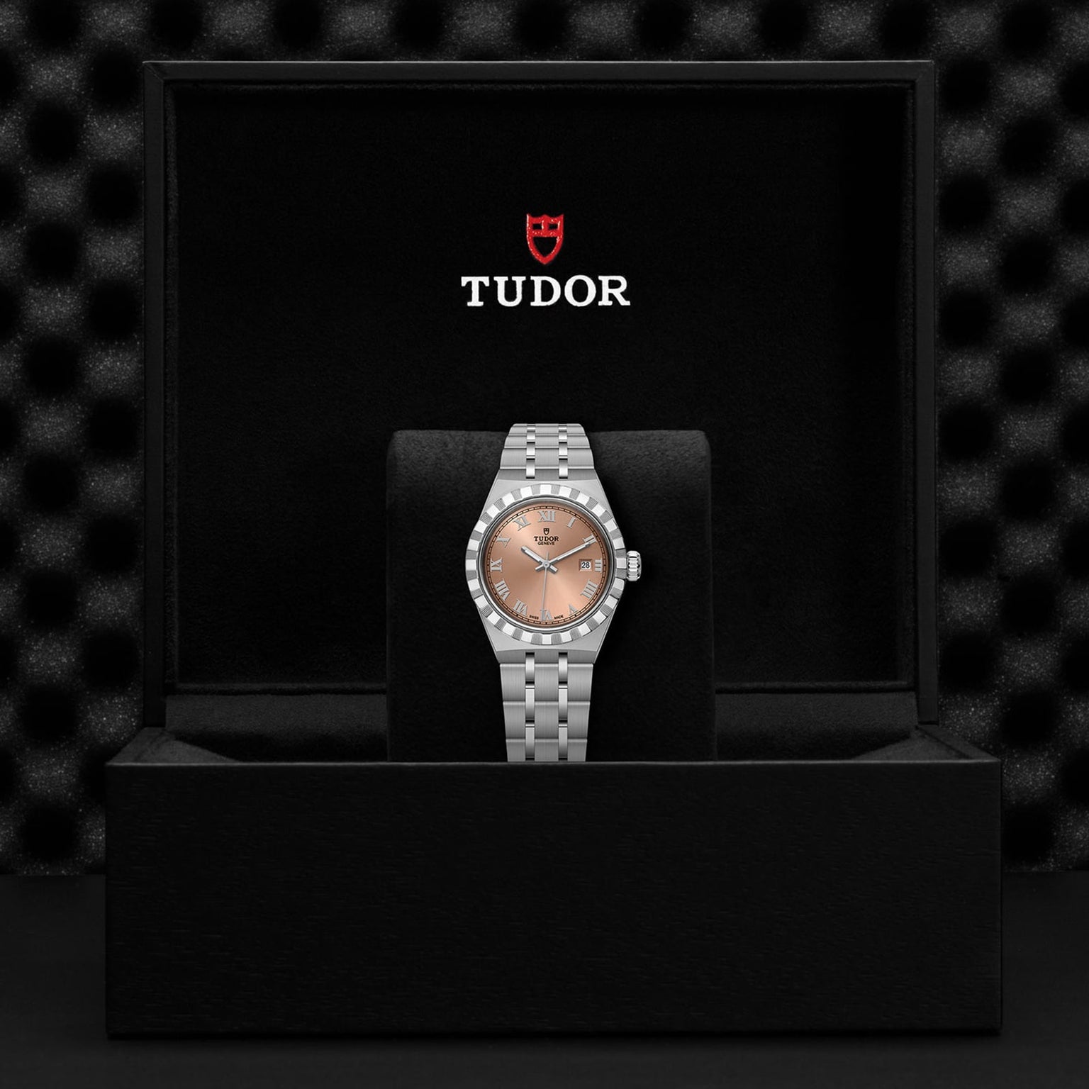 A TUDOR Royal wristwatch with a silver band and copper dial, automatic movement, shown in an open black TUDOR box with the logo on the lid.