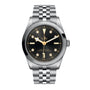 The TUDOR Black Bay One 36 is a stainless steel wristwatch featuring a black dial, gold hour markers, diamond accents, and a durable 316L steel bracelet, inspired by the iconic Black Bay models.