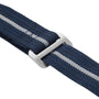 Close-up of a navy blue fabric strap with a gray metal buckle and a central white stripe, inspired by straps on the TUDOR Pelagos FXD watch.