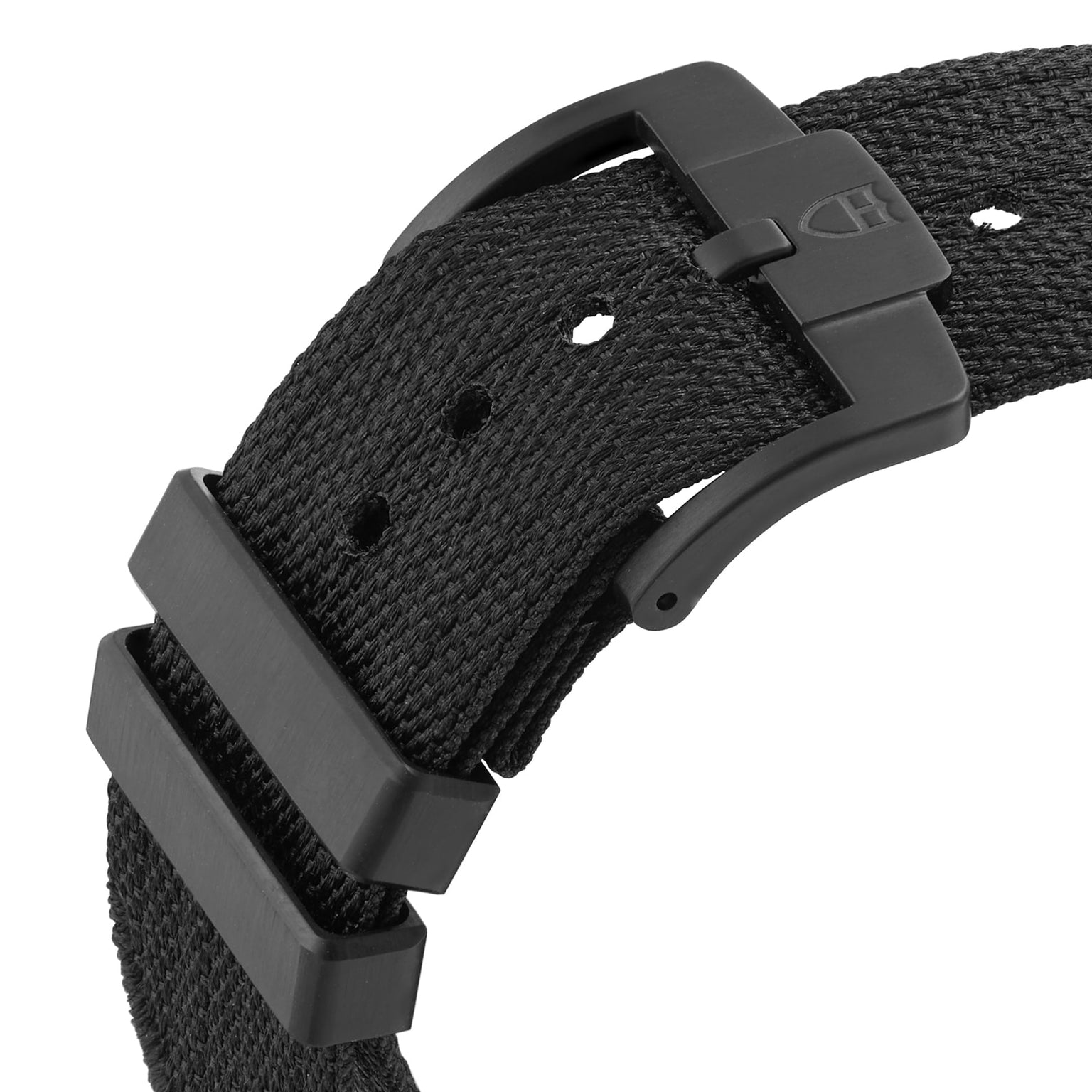 Close-up of a black fabric watch strap with black metal buckle and two loops, designed for the TUDOR Pelagos FXD Chrono cycling-themed chronograph, featuring multiple adjustment holes.