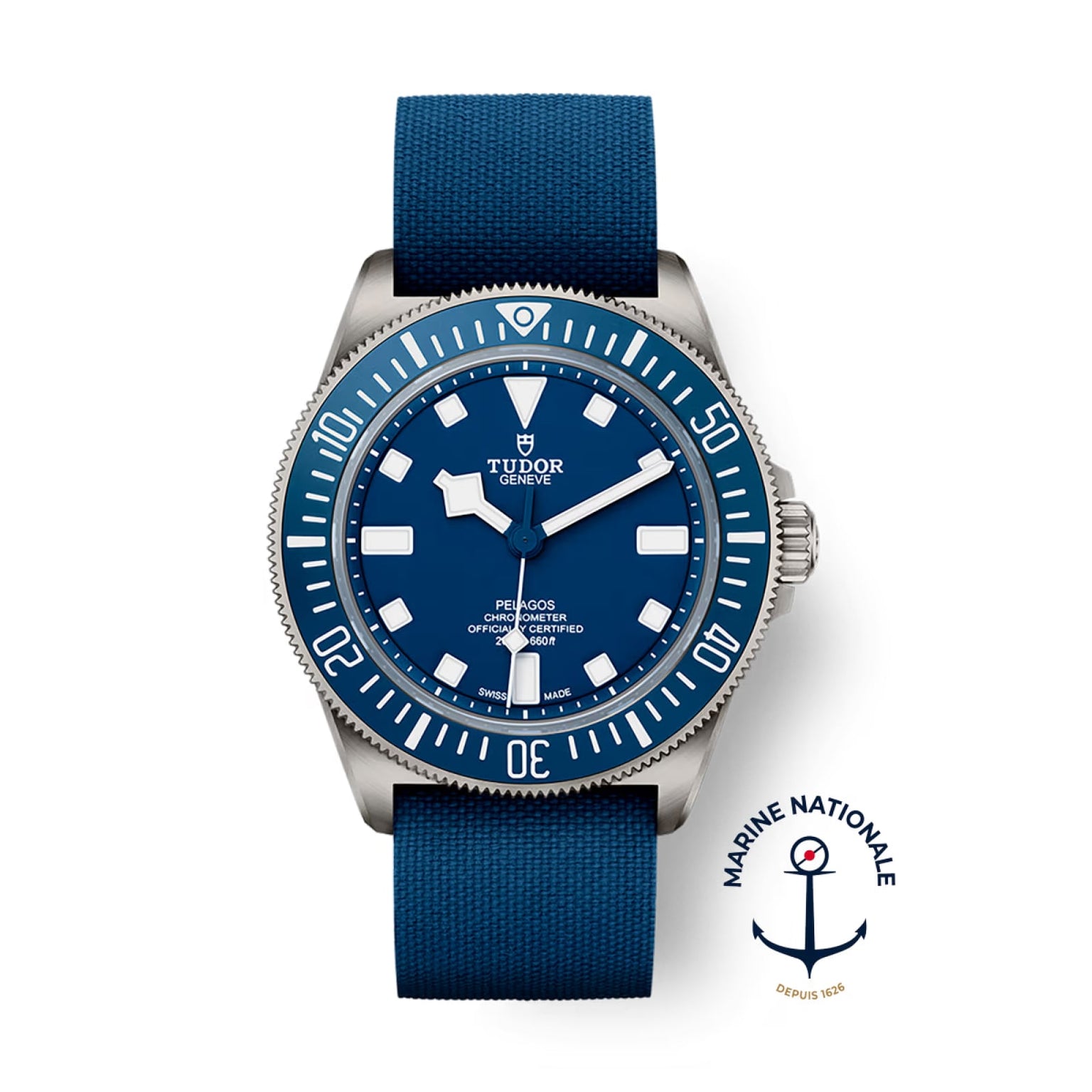 The TUDOR Pelagos FXD dive watch features a blue dial and bezel, blue fabric strap, titanium case, and the Marine Nationale logo in the lower right corner.