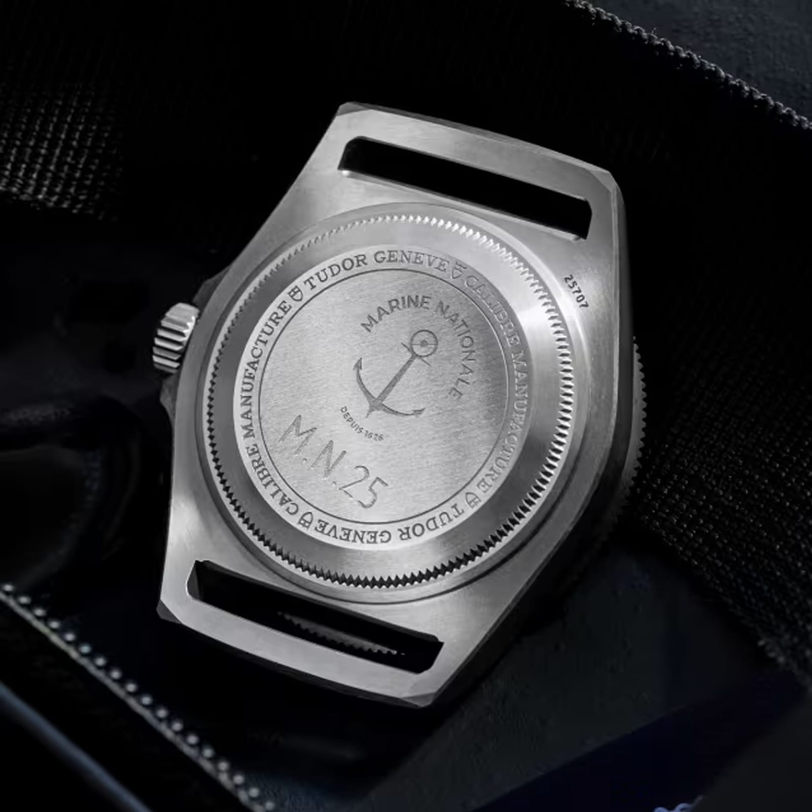 Close-up of the titanium case back on the TUDOR Pelagos FXD, engraved with Marine Nationale, an anchor emblem, M.N.25, and manufacturer details; water resistant to 200m.