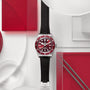 The TUDOR Black Bay 58 wristwatch, featuring red and silver accents and a black strap, is displayed on a geometric red and white background.