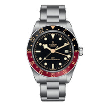 The TUDOR Black Bay 58 GMT is a stainless steel dive watch with a black dial, red and blue bezel, date window at 3 o’clock, and a sturdy metal bracelet.