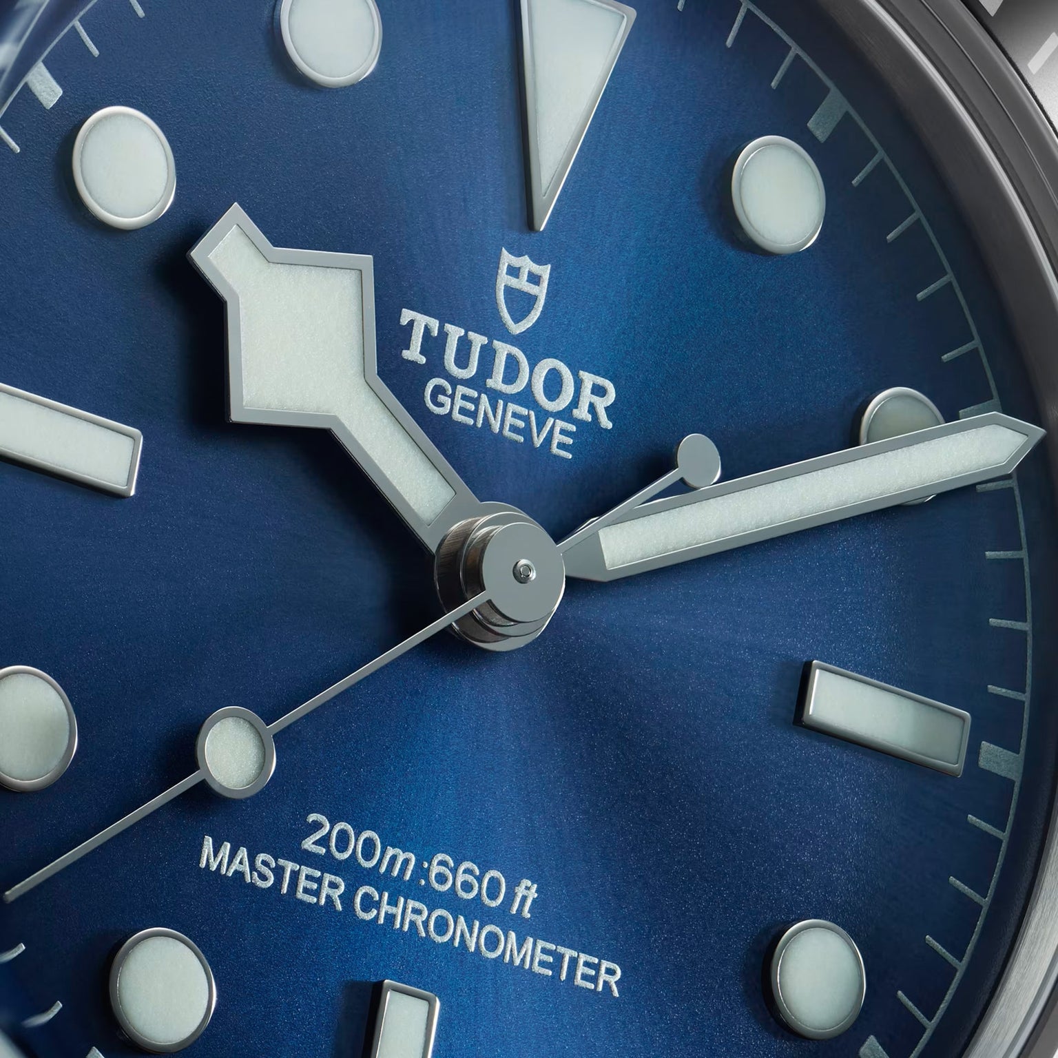 Close-up of a TUDOR Black Bay 68 watch face in blue, featuring bold hands and markers, with 200m:660ft indicated.