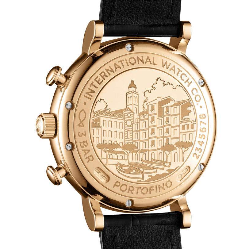 Close-up of the IWC Schaffhausen Portofino Chronographs 18ct 5N gold case back, engraved with a building scene and labeled INTERNATIONAL WATCH CO. PORTOFINO 3 BAR, on a black leather strap with automatic self-winding movement.