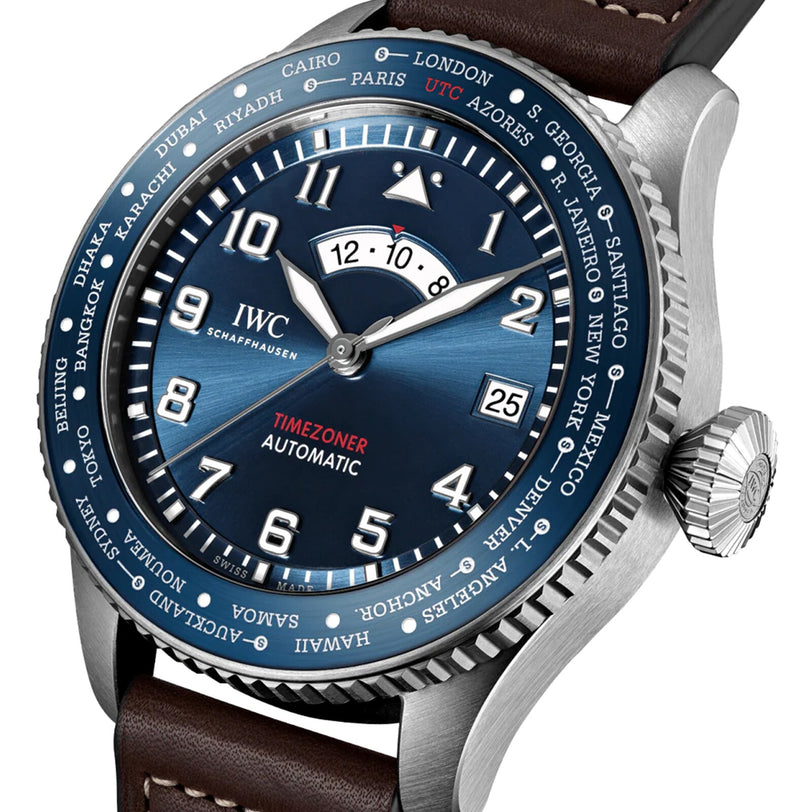 Close-up of the IWC Schaffhausen Pilots Watch Timezoner Edition Le Petit Prince, with a blue dial, stainless steel case, world cities bezel, and brown leather strap.
