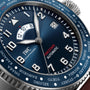 Close-up of the IWC Schaffhausen Pilot’s Watch Timezoner Edition Le Petit Prince, featuring a blue dial, multiple time zones, date display, and a rotating stainless steel bezel engraved with city names.