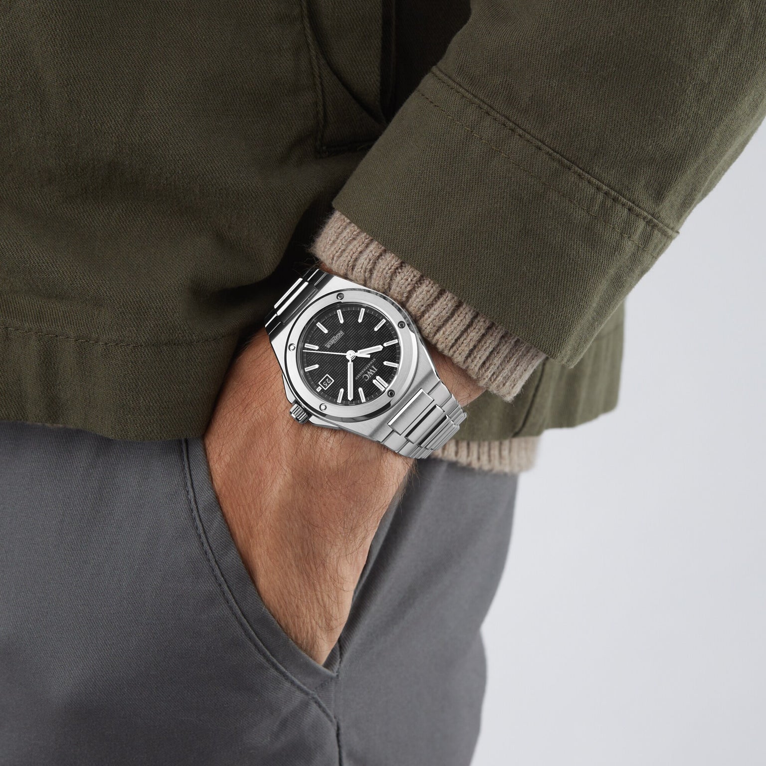 Wearing the IWC Schaffhausen Ingenieur Automatic 40, a silver wristwatch with a black dial, and gray pants with one hand in the pocket.