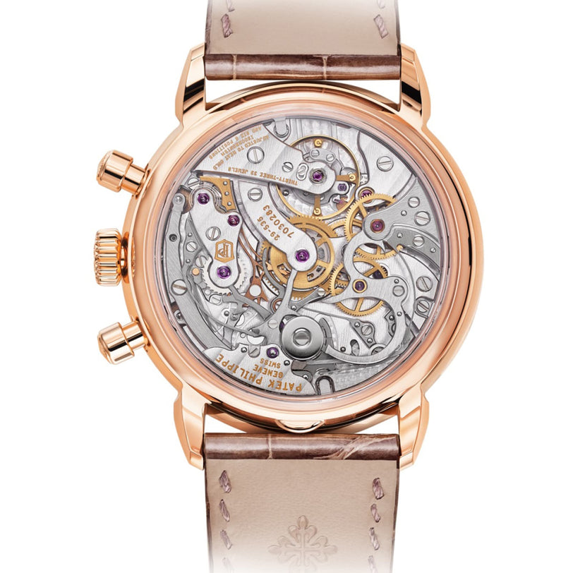 The Patek Philippe Complication 7150/250R-001 is a luxury watch featuring a rose gold case and a transparent back that reveals its intricate mechanical movement.
