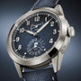 Patek Philippe Complications 5328G-001 watch featuring a blue textured dial, white numerals, and a blue leather strap.