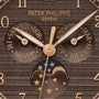 Close-up of the Patek Philippe Complications 4946R-001 watch face displaying day, month, and moonphase in gold and brown tones.
