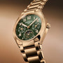 Patek Philippe Twenty~4 7340/1R-010: gold wristwatch featuring a green dial, date subdials, moon phase display, and gold bracelet.