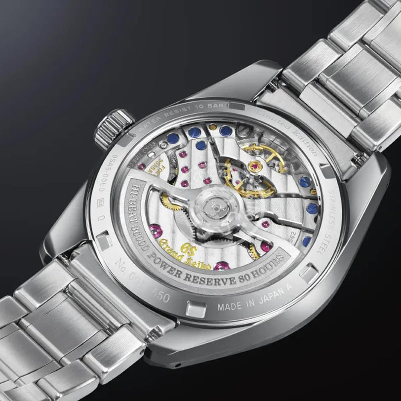 Close-up of the back of a Grand Seiko Hi-Beat Heritage stainless steel watch, revealing its precise mechanical movement and engraved caseback details.