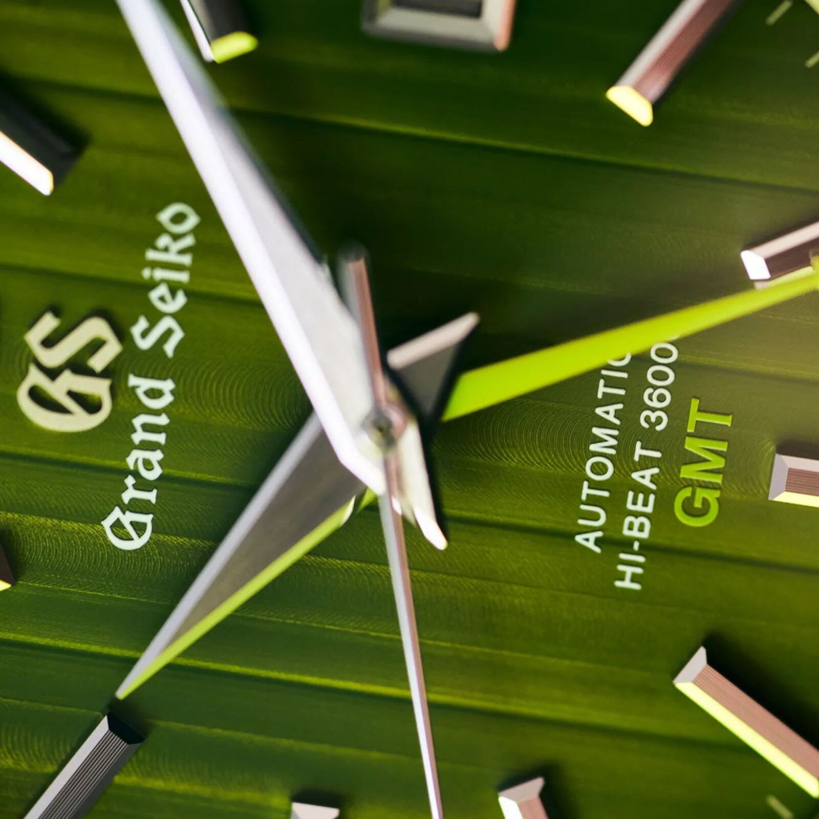 Close-up of a green Grand Seiko Hi-Beat GMT Heritage watch face, inspired by bamboo paths, showing hands, hour markers, and AUTOMATIC HI-BEAT 36000 GMT with Hi-Beat Caliber 9S86.