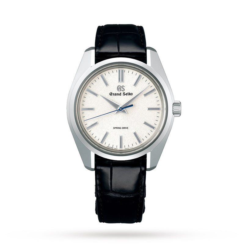 A Grand Seiko Spring Drive Heritage watch featuring a silver textured dial, silver indices, black leather strap, and three central hands.