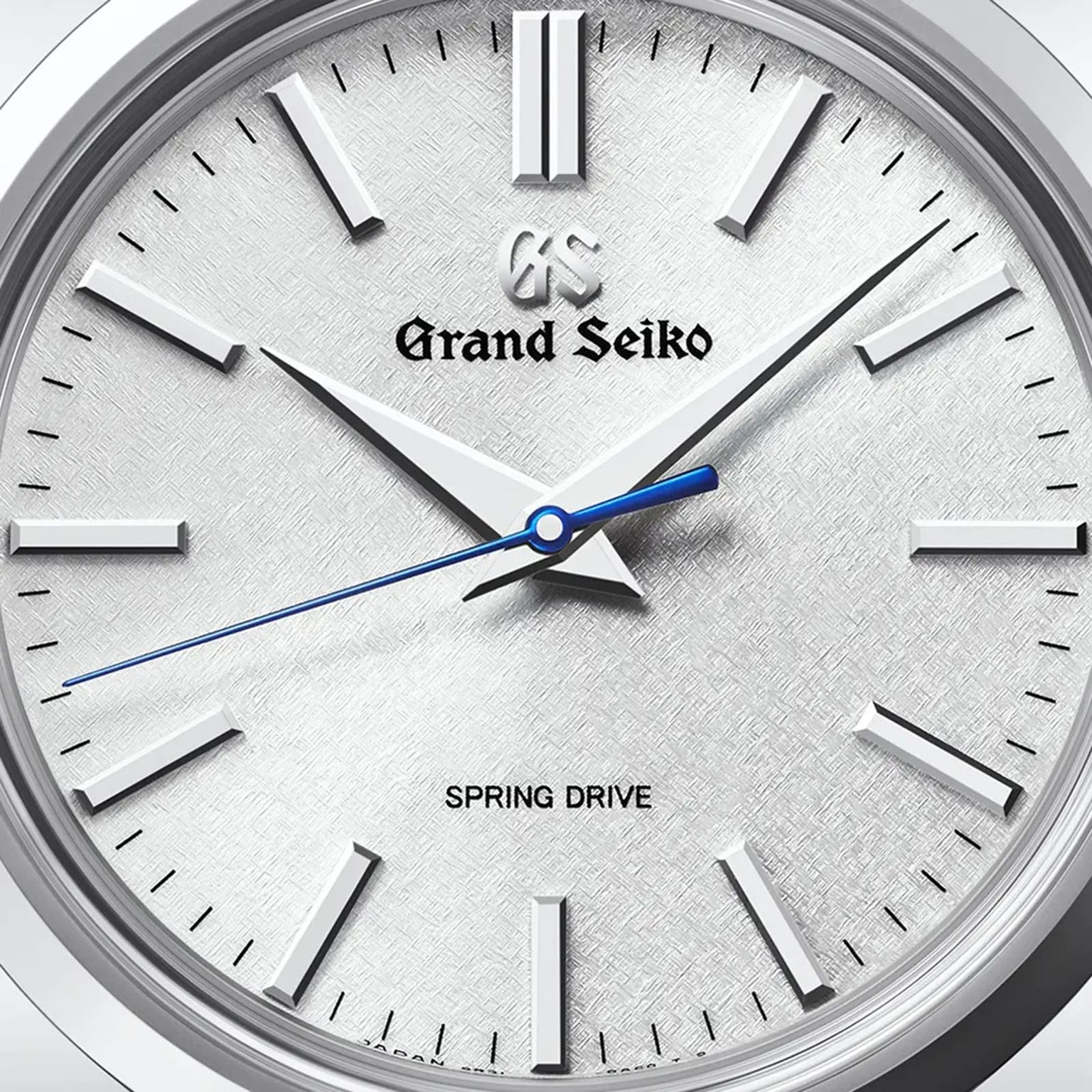Close-up of a Grand Seiko Spring Drive Heritage watch face with silver hour markers, silver hands, and a blue second hand, displaying the time as 10:08:36.