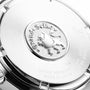 Close-up of the back of a Grand Seiko Quartz Heritage watch, featuring the engraved lion emblem, brand name, and manufacturing details on its polished stainless steel surface.