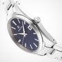 A close-up of the Grand Seiko Quartz Heritage watch, showcasing its black dial, silver hour markers, and a sleek stainless steel bracelet.