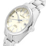 A close-up of the Grand Seiko Hi-Beat Heritage wristwatch with a silver Ever-Brilliant Steel band and case, light champagne dial, date at 3 oclock, and Automatic Hi-Beat 36000 marked on the face.