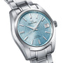 A close-up of the Grand Seiko Hi-Beat Heritage wristwatch, featuring a stainless steel case, light blue textured dial, date window at 3 o’clock, and a silver metal bracelet.