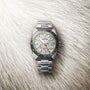 The Grand Seiko Spring Drive GMT Sport features a textured dial and GMT bezel, powered by the Spring Drive 9R66 Caliber, shown on a soft, fur-like background.