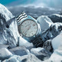 The Grand Seiko Hi-Beat Heritage wristwatch, crafted from High-Intensity Titanium with a textured white dial, is displayed among ice-like rocks beneath a blue sky.