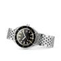 The DOXA Sub 200 Sharkhunter is a 316L stainless steel divers watch featuring a black dial, yellow and white hour markers, date window, and linked metal bracelet band, shown against a white background.