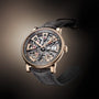 The Arnold & Son Nebula 41.5 Red Gold features a skeleton dial with exposed gears, a rose gold case, and a black leather strap, elegantly displayed against a gradient background.