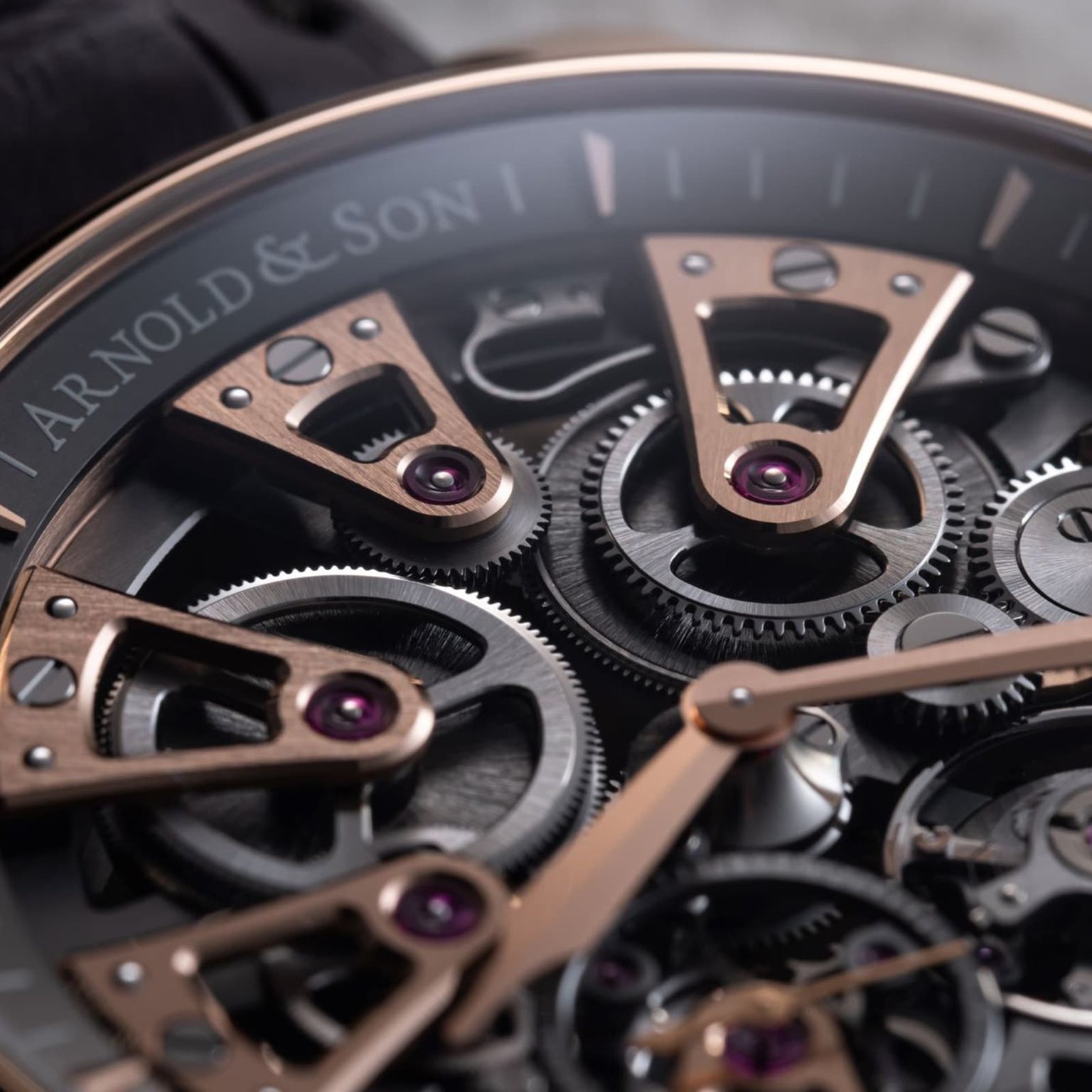 Close-up of the Arnold & Son Nebula 41.5 Red Gold watch, highlighting its exposed gears and elegant rose gold details.