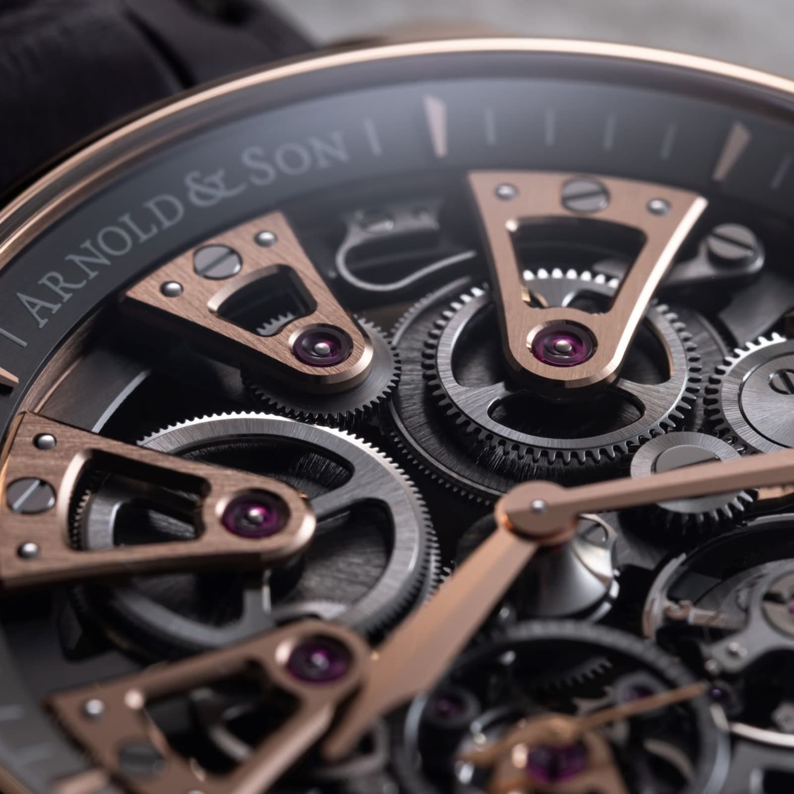 Close-up of the Arnold & Son Nebula 41.5 Red Gold watch, highlighting its exposed gears and elegant rose gold details.