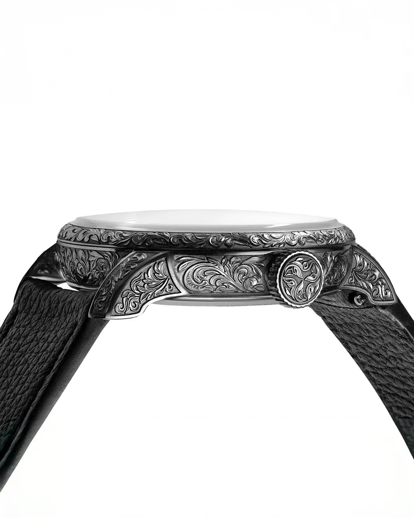 Close-up of an intricately designed watch band with detailed engravings on a white background